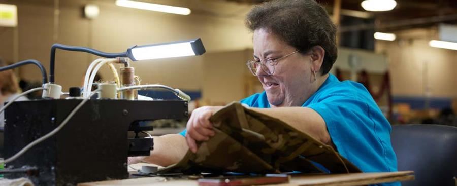  Christina Atkinson uses a heat cutter to remove excess material from a bandoleer pouch.
